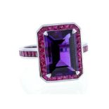 A ruby and amethyst 18ct white gold dress ring, by Fabricius Green, comprising a claw set emerald