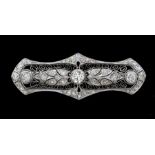 An Edwardian diamond and platinum brooch, comprising an elongated pierced form, with leaf decoration