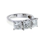 A three stone diamond and 18ct white gold ring, comprising three princess cut diamonds, assessed