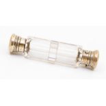 A 19th Century double ended facet cut clear glass scent bottle, with white metal covers, one