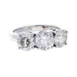 A three stone diamond 18ct white gold ring, comprising three round brilliant cut diamonds law set,