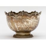 An Edwardian silver small punch bowl, wavy border with applied masks, plain body with inscription:
