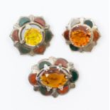 A collection three Scottish plaid brooches, each one set with a faceted glass centre, within a