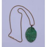 A Jade pendant and high ct gold chain