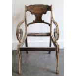 A Regency ebonised and parcel-gilt armchair, c 1815, the shaped oblong toprail decorated with