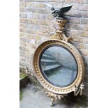 A regency giltwood and gesso mirror, c 1820.  the circular convex plate within a ball-decorated