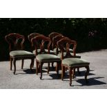 A set of six mid Victorian dining chairs, with wavy shaped backs on upholstered padded seats, raised