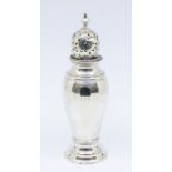 An Edwardian silver faceted caster, domed pierced cover with baluster finial, the body engraved ECC,