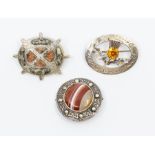 A collection of three Scottish hardstone plaid brooches to include one an open oval engraved
