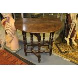 An early 18th Century joined oak gateleg table, of small proportions, plank top, raised on turned