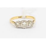 A three stone diamond and 18ct gold ring, comprising three claw set brilliant cut diamonds, total