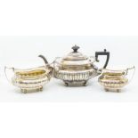 An Edwardian three piece silver tea set including teapot, sugar bowl, cream jug, shell and scroll