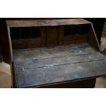 A George III oak bureau, the fall front enclosing a fitted interior with drawers and pigeon holes,