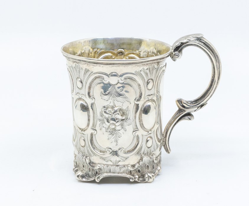 A Victorian parcel gilt mug, the body chased with panels of flowers, oval between, on scroll