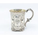 A Victorian parcel gilt mug, the body chased with panels of flowers, oval between, on scroll
