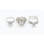 A collection of three dress rings to include two white metal rings set large cubic zirconia and