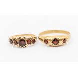 Two 9ct gold and garnet set rings, including a five stone ring with decorative shoulders, size O,