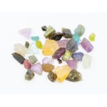 A collection of rough cut gem stones/ crystals, apatite, aquamarine, peridot, amethysts, fluorite,