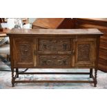 A George V oak sideboard, having two cupboards and two drawers, machine carved front, the back