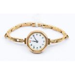 A 9ct gold ladies wristwatch, white enamel dial number markers, on a plated expandable strap,