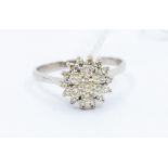 A diamond and 18ct white gold cluster ring, comprising a claw set cluster of round brilliant cut