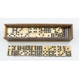 Early 20th century ebony and ivory dominos set in wooden box.