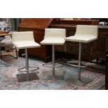 Three Italian Frag cream leather upholstered swivel chairs, with adjustable height seats, foot