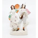 A Staffordshire flatback figure modelled as a Gentleman playing lute and a Lady with tamborine (1)