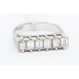 A diamond and platinum ring, comprising six baguette cut diamonds claw set in a row, total diamond