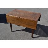 An early 19th Century oak drop leaf dining table, circa 1820, fitted with two drawers, raised on