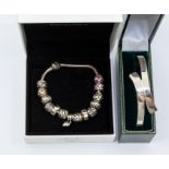 A silver Pandora bracelet, including fourteen white metal charms to include hearts, stone set and