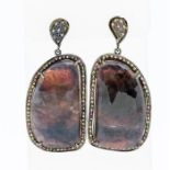A pair of large stone set silver drop earrings, comprising a central rose cut pink/purple sapphire
