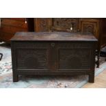 A late 17th Century joined oak chest, plank top, having a two panelled front carved with arcaded