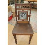 A Scottish Arts and Crafts oak hall chair, the back fitted with a ceramic tile inscribed 'Fair