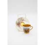 A Royal Worcester small coffee (cabinet) cup and saucer, gilt interior, handle and rim to cup,