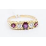 A ruby and diamond 18ct gold boat head ring, comprising an oval central ruby, set either side by a