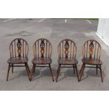 An Ercol set of four Fleur De Lys beech and elm seated dining chairs (4)
