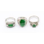 A collection of stone set white metal rings to include an emerald and diamond set ring, claw set