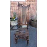 A William and Mary period and later walnut high backed chair, having a canework seat, carved crest