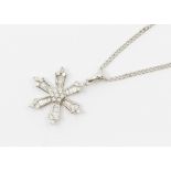 An 18ct white gold and diamond set snow flake pendant, comparing tapered channel set baguette cut
