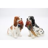 A pair of Royal Doulton spaniels carrying pheasants, stamped with painted model numbers HN1028 &