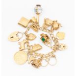 A 9ct gold charm bracelet, including a 1976 sovereign coin, iron chain, fish etc. Total gross approx