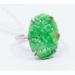 A carved jade and white metal dress ring, the oval jade with foliate caved and pierced decoration,