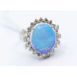 An opal and diamond cluster ring comprising an oval opal approx 12 x 14mm, claw set within a
