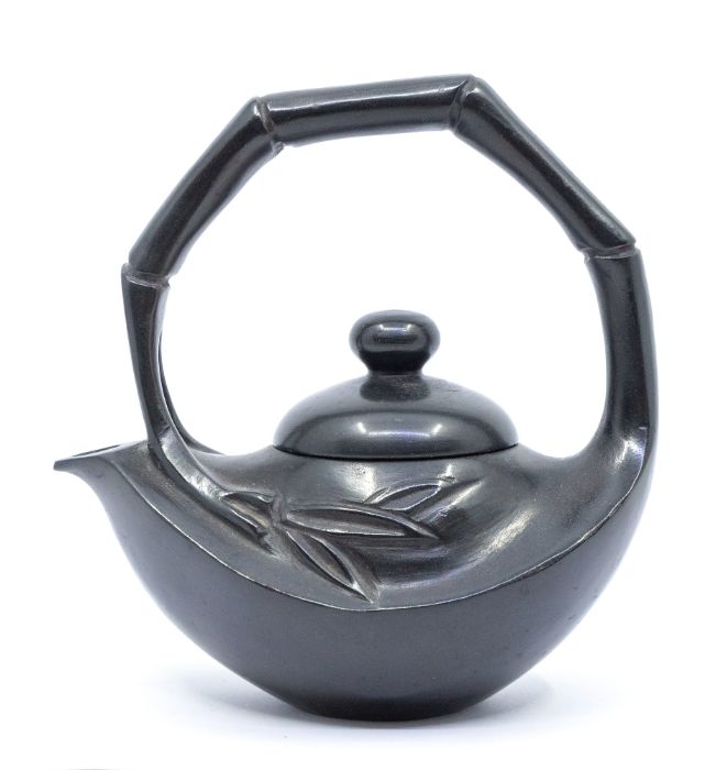 A black shousan stone teapot and cover, carved with a simulated bamboo overstrung handle, over a