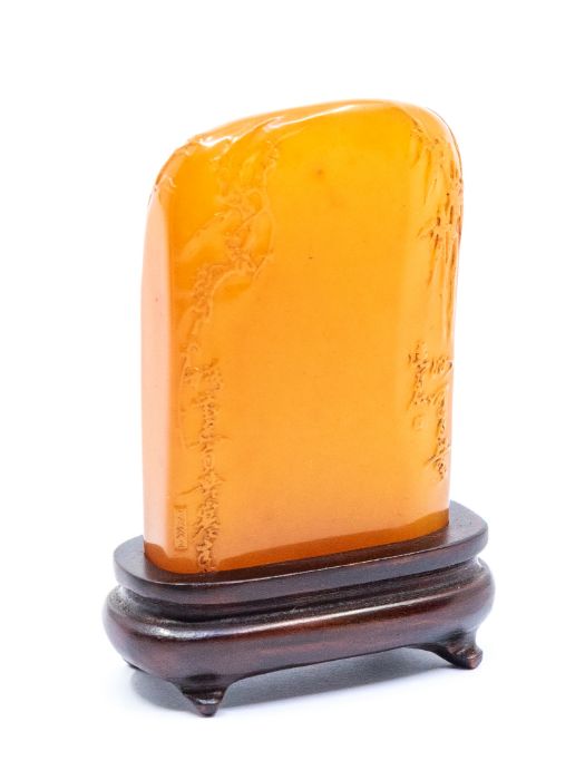 An orange jelly seal, carved with foliage to the upper sections of each side and inscribed with