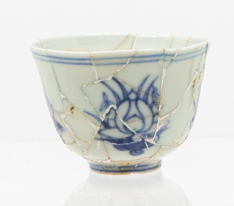 A Chinese blue and white ‘lotus’ cup, the gently rounded sides rising form a short foot, to a