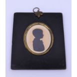 A 19th century silhouette portrait in ebony frame, inscribed in verso, Donald Grant