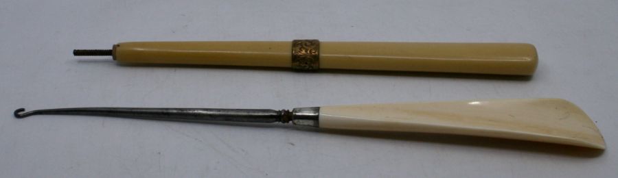 An early 20th century combined shoehorn/button hook and an ivoreen parasol handle with gilt metal