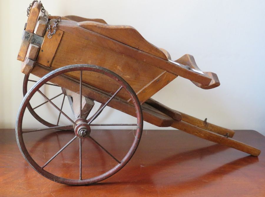 An early 20th century model of a wooden pony trap with metal fittings and spoked metal wheels,